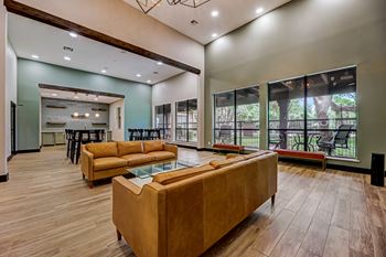 A living room with couches and a glass table    and a kitchen